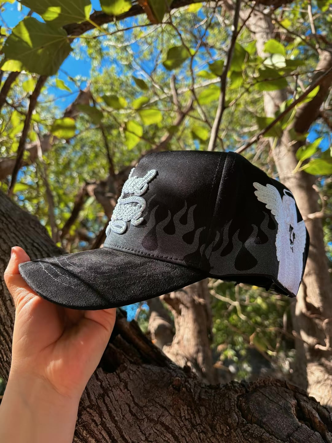 Vista lateral de gorra negra con visera curva y diseño de llamas