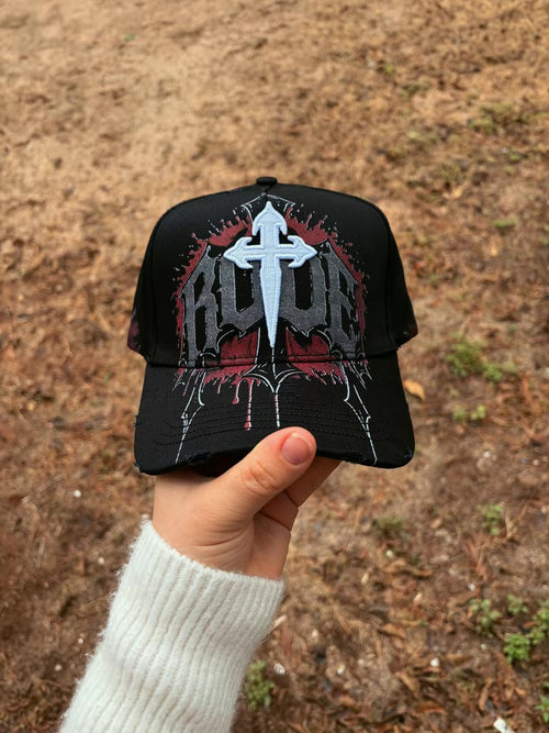 Vista frontal de gorra negra con cruz clara y gráficos grises y rojos